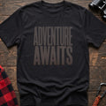 Black t-shirt with large distressed gray text reading Adventure Awaits