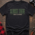 Black cotton t-shirt with Almost There Biggest Lie in Hiking text on rustic wood