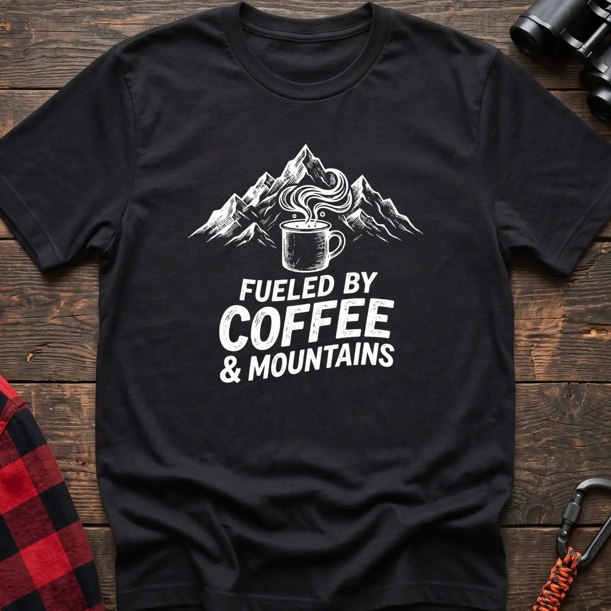 Black t-shirt with white graphic of a steaming coffee mug in front of mountains and the text Fueled by Coffee & Mountains