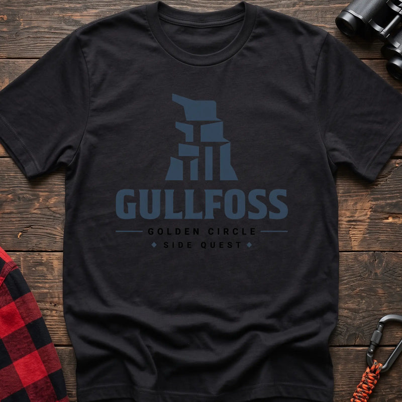 Black cotton t-shirt with a stylized waterfall graphic and Gullfoss Golden Circle Side Quest text on rustic wood
