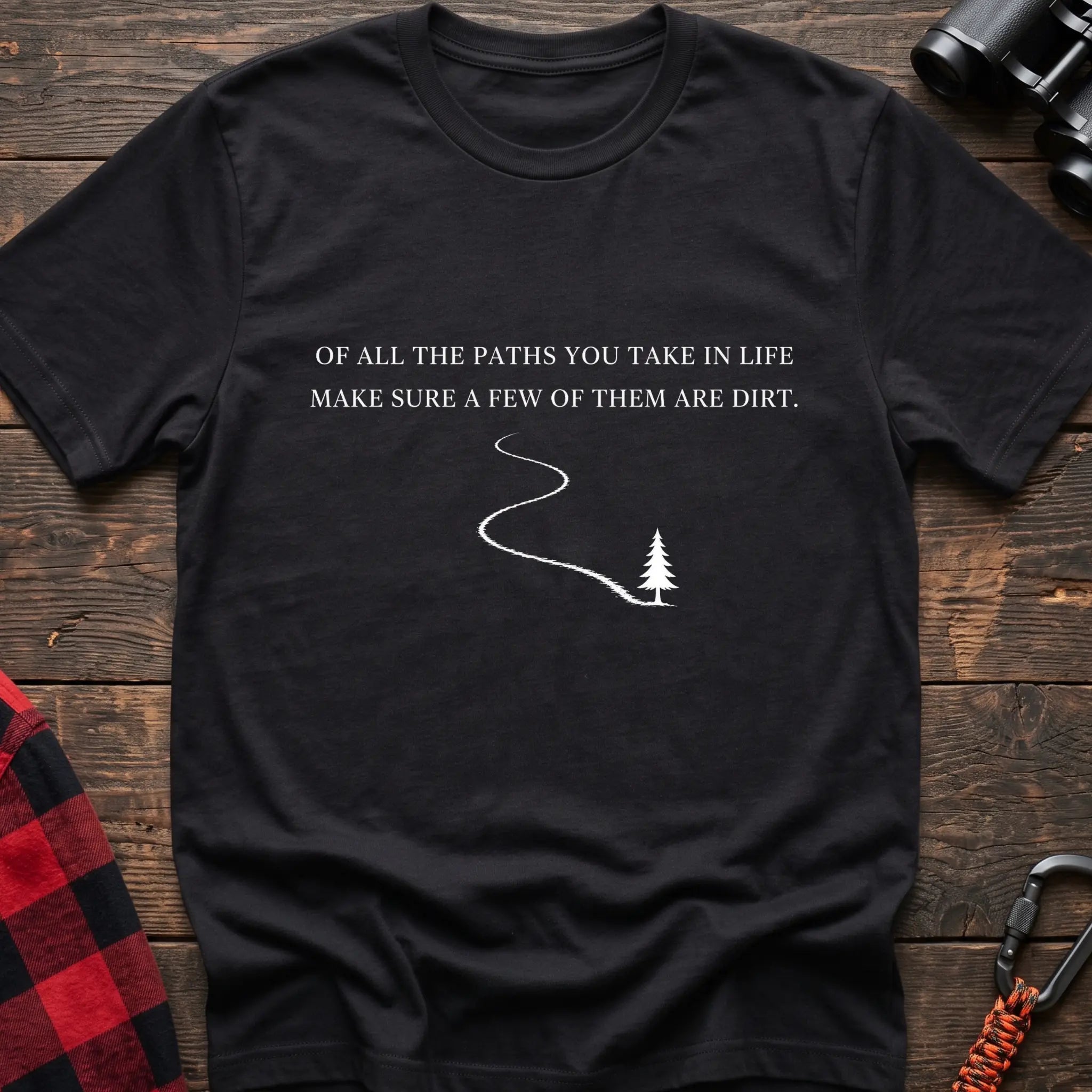 Black cotton hiking t-shirt with white quote "Of all the paths you take in life make sure a few of them are dirt" and winding dirt path to pine tree graphic