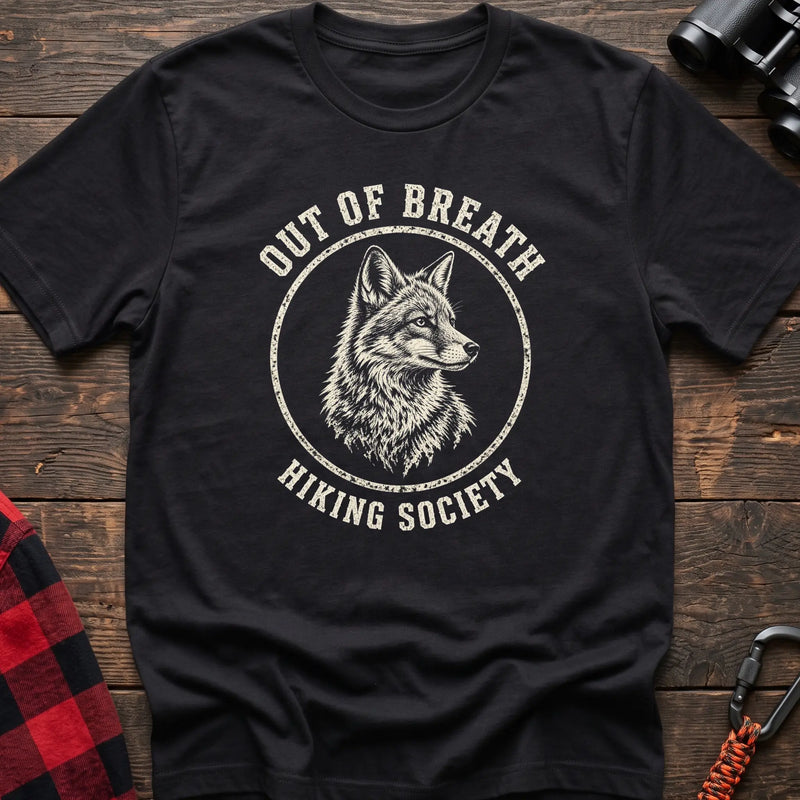 Black cotton t-shirt with a wolf graphic and Out of Breath Hiking Society text on rustic wood