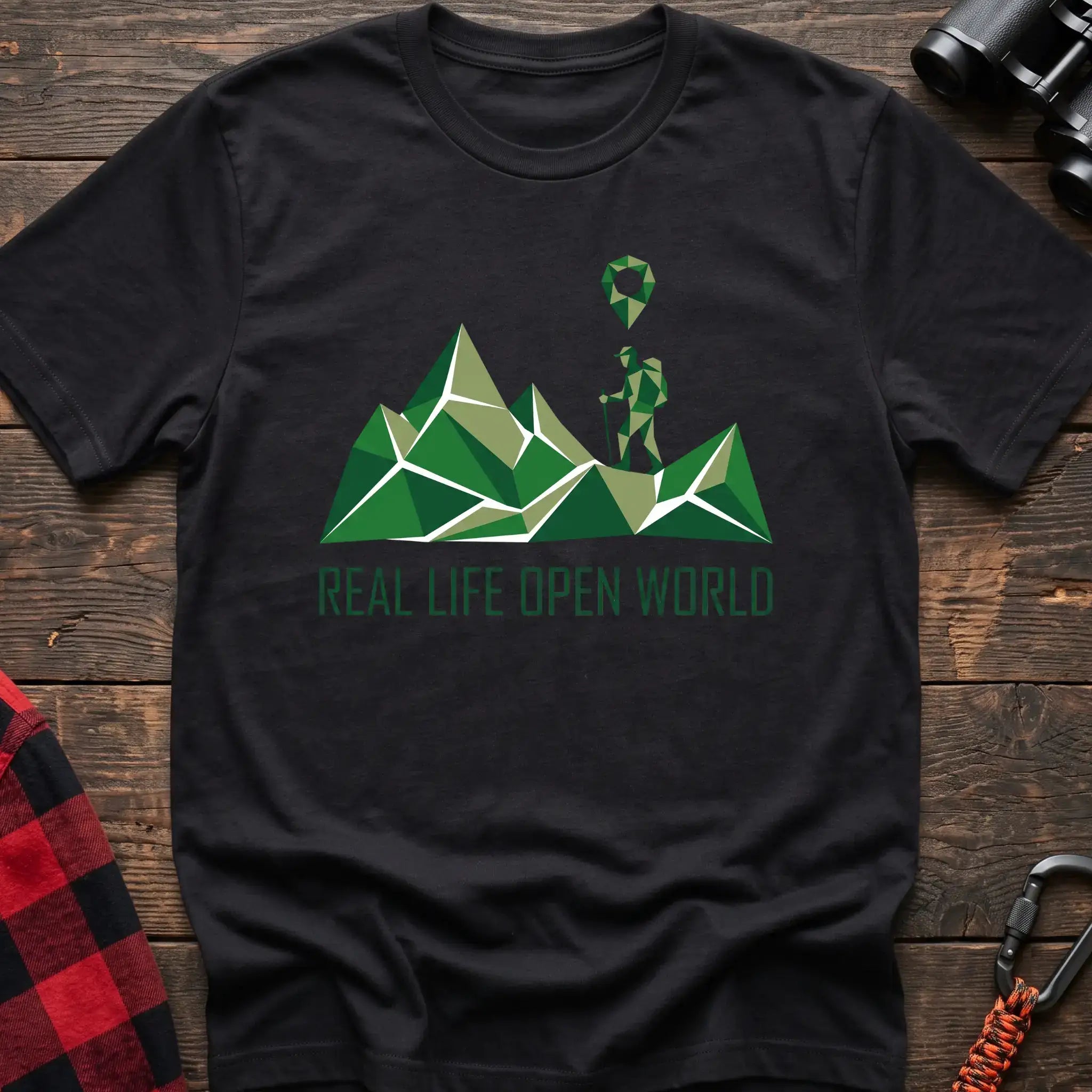 Black t-shirt with geometric green mountain graphic and a hiker silhouette under a map pin, reading Real Life Open World