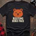Black cotton t-shirt with a grumpy bear graphic and Resting Hike Face text on rustic wood