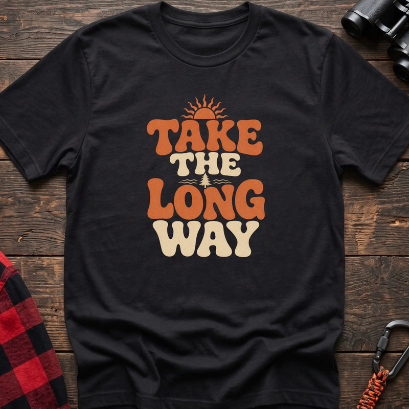 Black cotton t-shirt with retro wavy text and Take the Long Way lettering on rustic wood