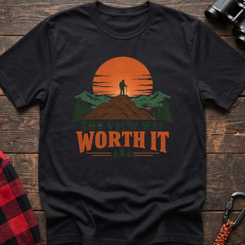 Black cotton t-shirt with a hiker on a mountain sunset graphic and The View Was Worth It text on rustic wood