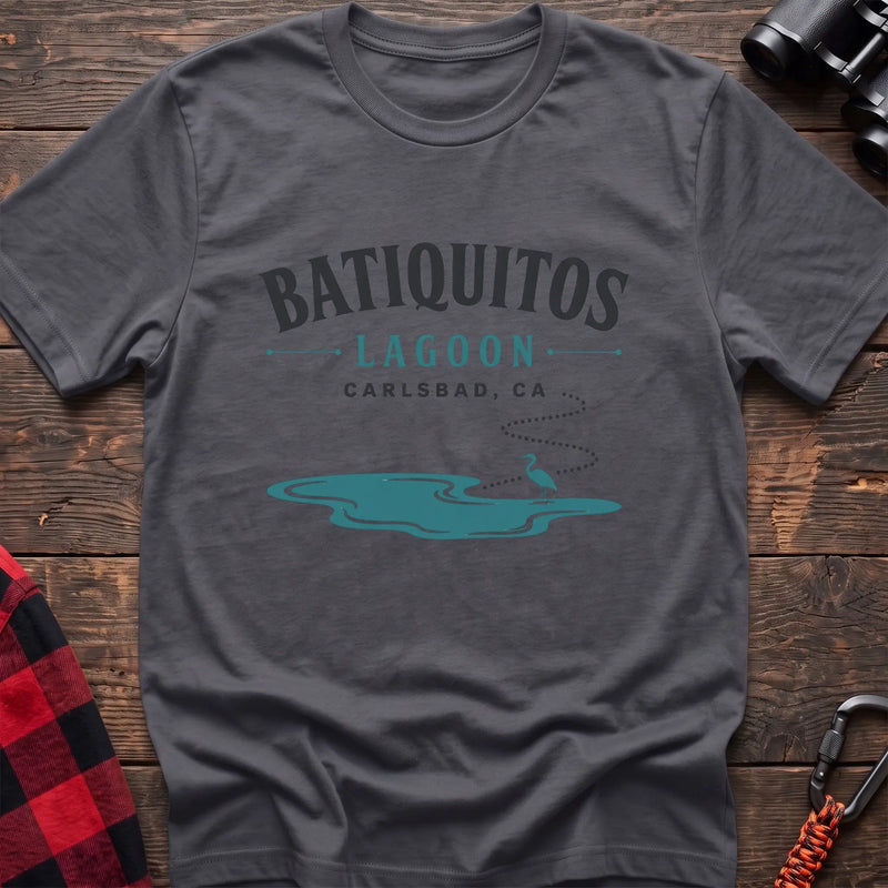 Charcoal cotton t-shirt with a heron and lagoon graphic and Batiquitos Lagoon Carlsbad CA text on rustic wood