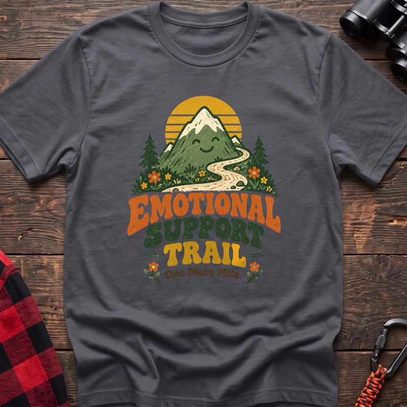 Charcoal cotton t-shirt with a smiling mountain and trail graphic and Emotional Support Trail text on rustic wood