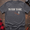 Charcoal cotton t-shirt with a trail and pine graphic and I’m Fixin’ to Hike text on rustic wood