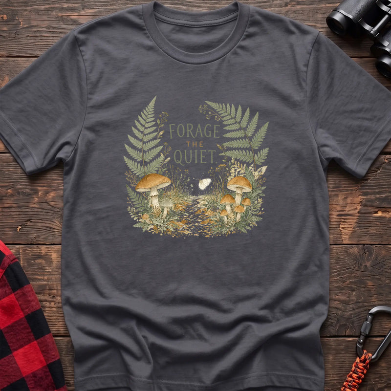 Charcoal cotton t-shirt with a mushroom and fern graphic and Forage the Quiet text on rustic wood