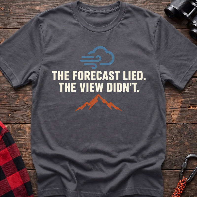 Charcoal cotton t-shirt with a wind cloud and mountain graphic and The Forecast Lied The View Didn’t text on rustic wood