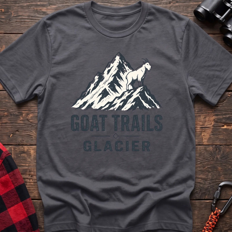 Charcoal cotton t-shirt with a mountain goat on a peak graphic and Goat Trails Glacier text on rustic wood