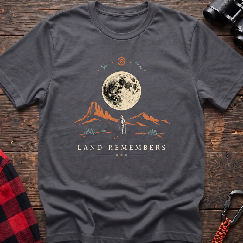 Charcoal cotton t-shirt with a desert hiker and full moon graphic and Land Remembers text on rustic wood