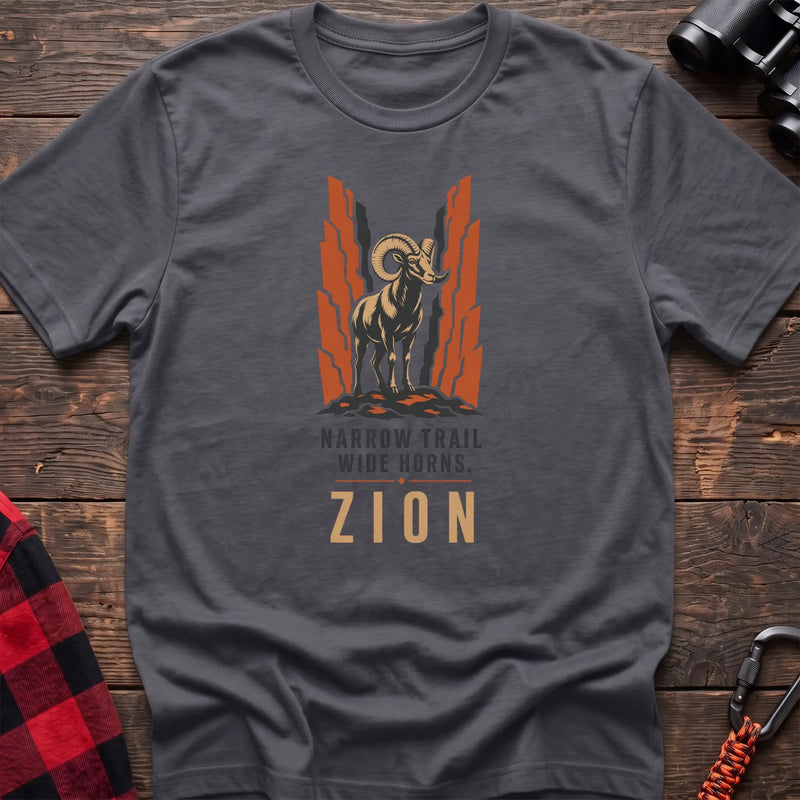 Charcoal cotton t-shirt with a bighorn sheep graphic and Narrow Trail Wide Horns Zion text on rustic wood