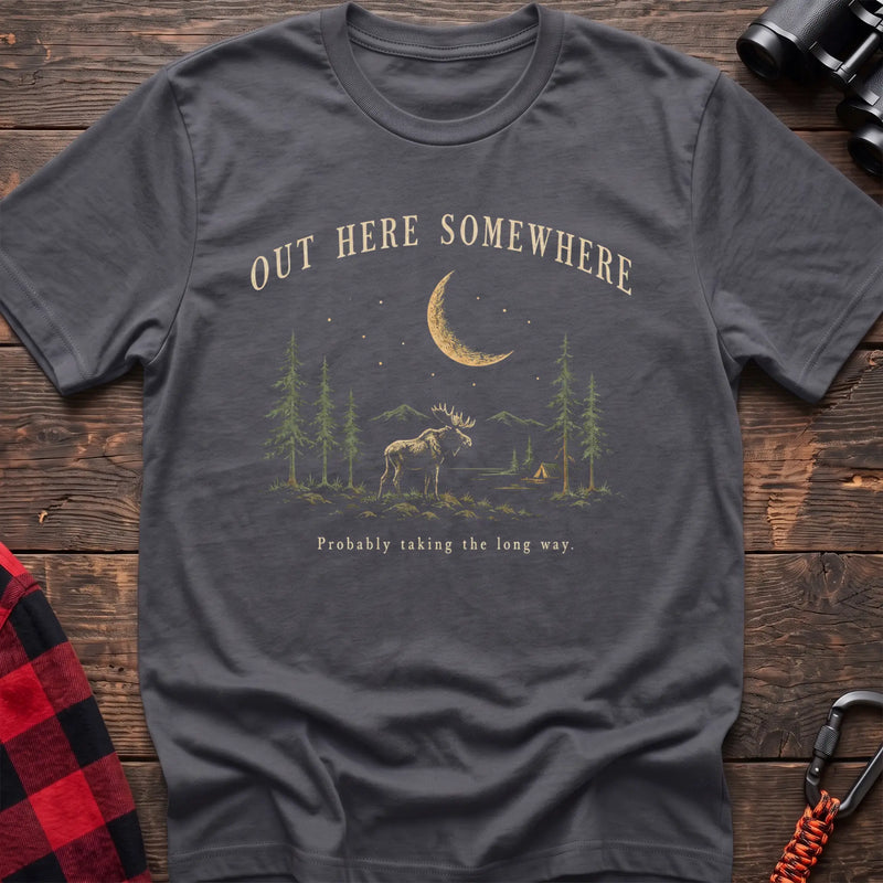 Charcoal cotton t-shirt with a moonlit moose and pines graphic and Out Here Somewhere text on rustic wood