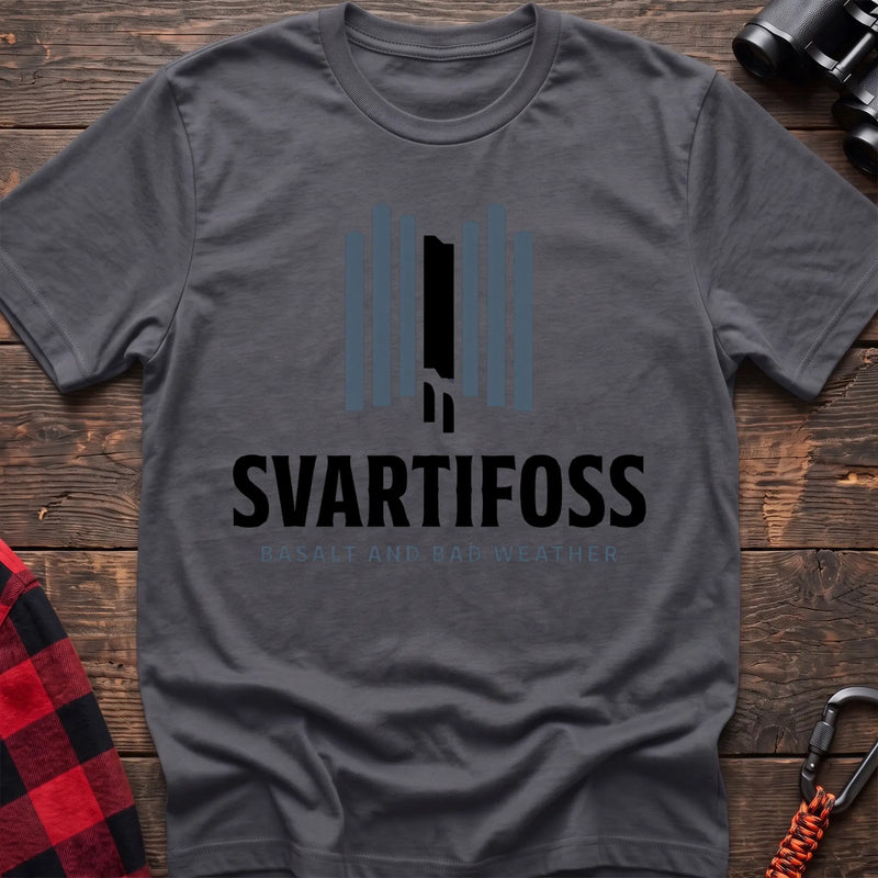 Charcoal cotton t-shirt with a basalt column graphic and Svartifoss Basalt and Bad Weather text on rustic wood