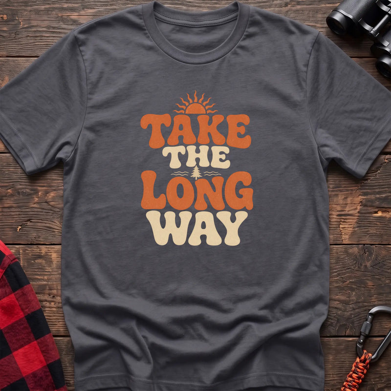 Charcoal cotton t-shirt with retro wavy text and Take the Long Way lettering on rustic wood