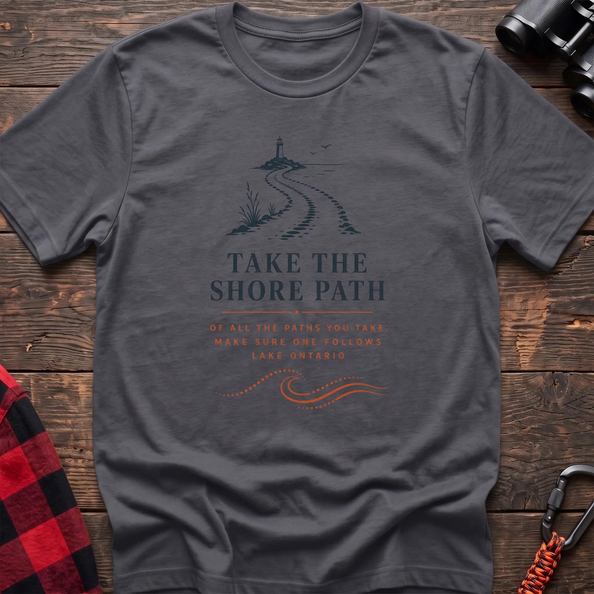 Charcoal cotton hiking t-shirt with lighthouse and winding shore path graphic and "Take the Shore Path – make sure one follows Lake Ontario" quote