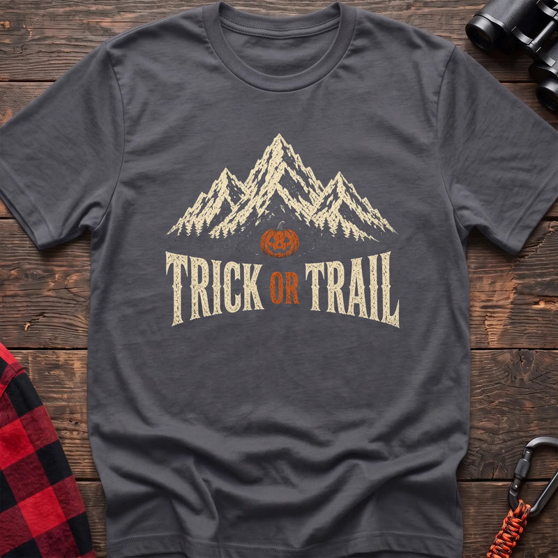 Charcoal cotton t-shirt with mountains, a jack-o’-lantern, and Trick or Trail text on rustic wood