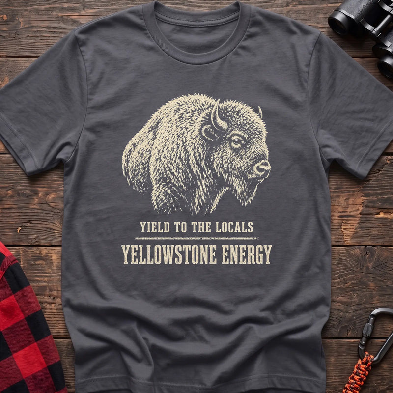 Charcoal cotton t-shirt with a bison graphic and Yield to the Locals Yellowstone Energy text on rustic wood
