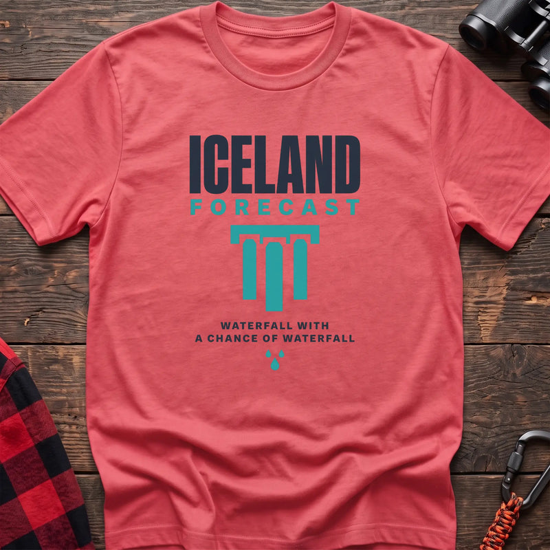 Coral silk cotton t-shirt with an Iceland Forecast graphic and Waterfall with a Chance of Waterfall text on rustic wood