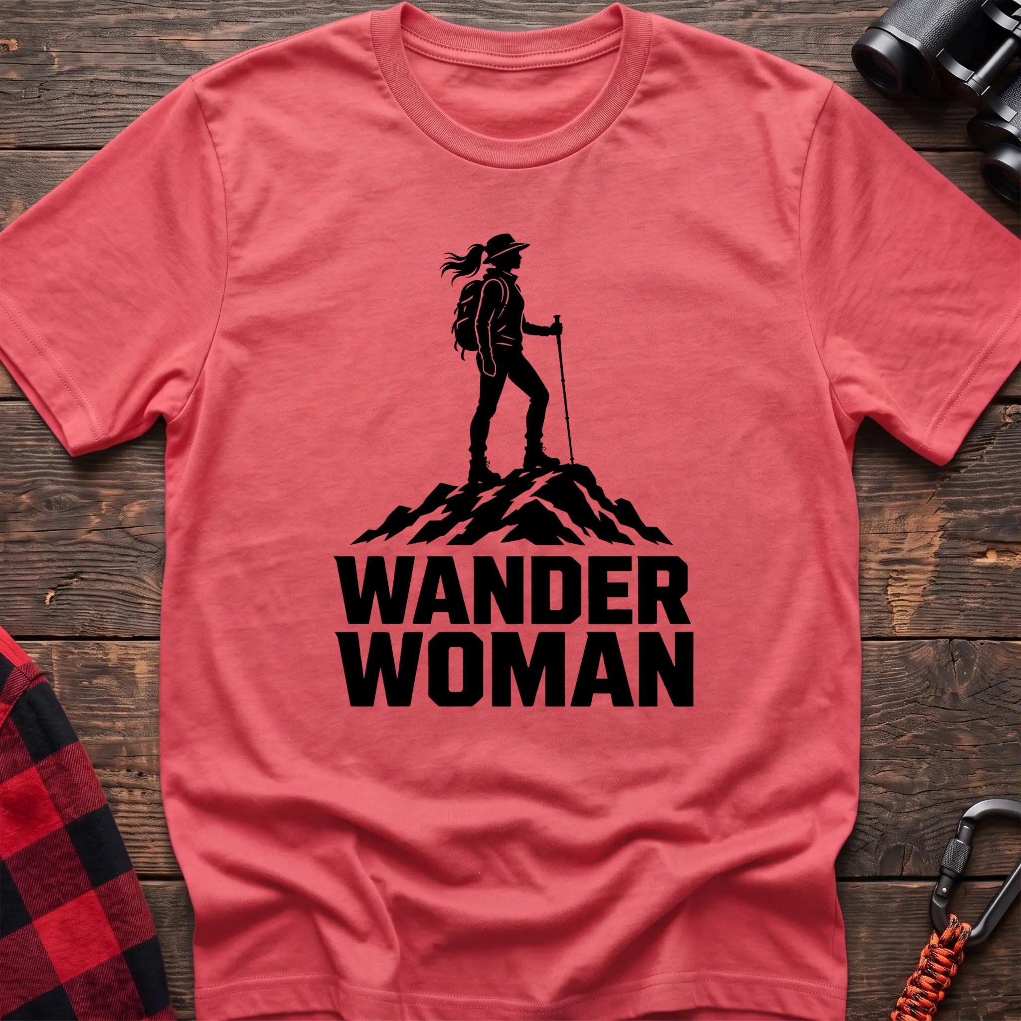 Coral silk cotton hiking t-shirt with black silhouette of a female hiker on a mountain peak and bold Wander Woman text