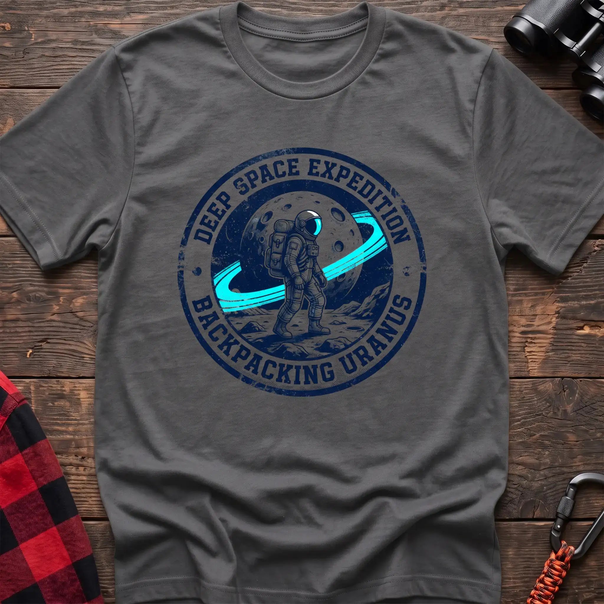 Graphite heather t-shirt with circular badge graphic of an astronaut backpacking on Uranus, reading Deep Space Expedition Backpacking Uranus