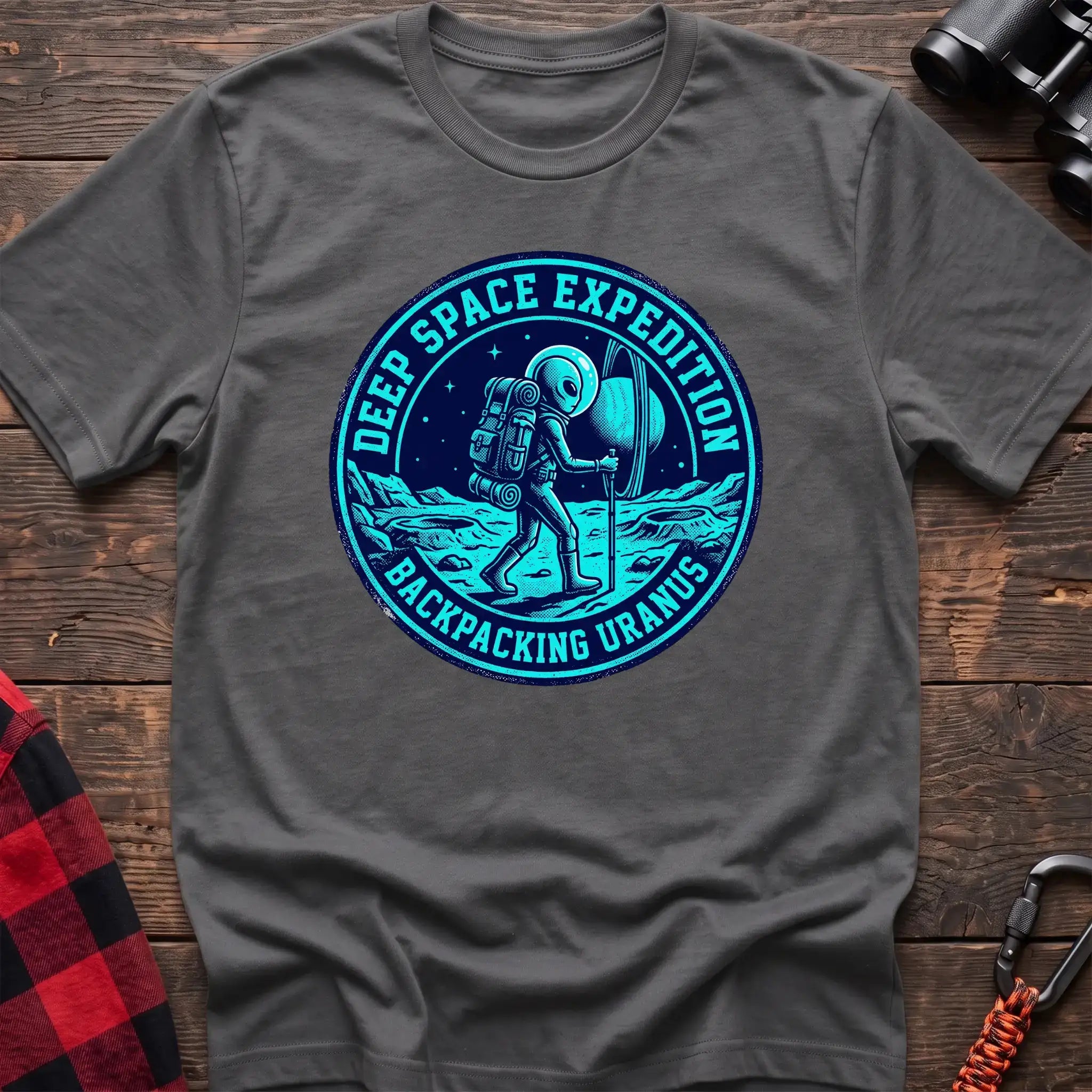 Graphite heather t-shirt with circular badge graphic of an alien backpacking on Uranus, reading Deep Space Expedition Backpacking Uranus