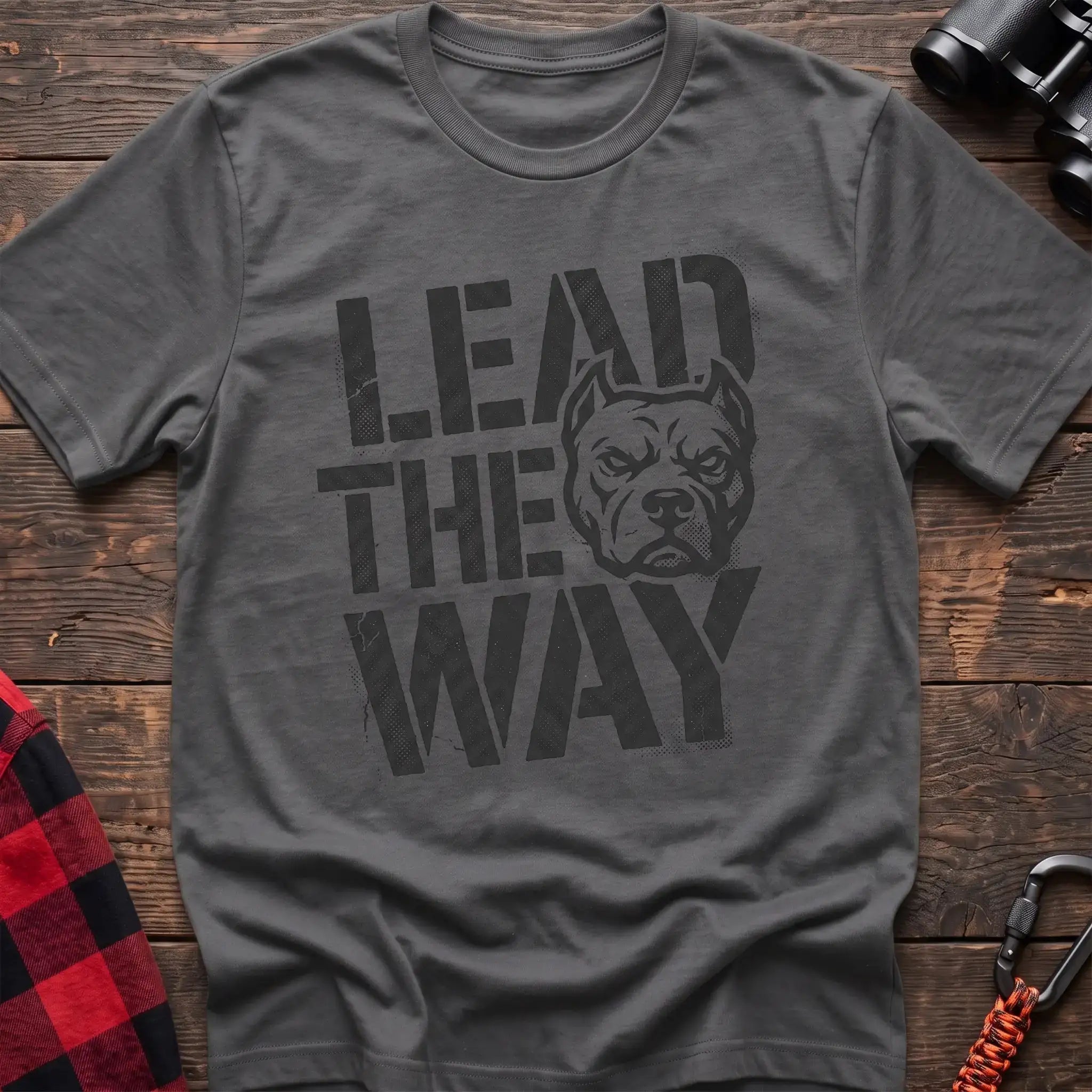 Graphite heather t-shirt with a distressed graphic of a stern pit bull head integrated into the bold text “LEAD THE WAY,” laid flat on a wooden surface.