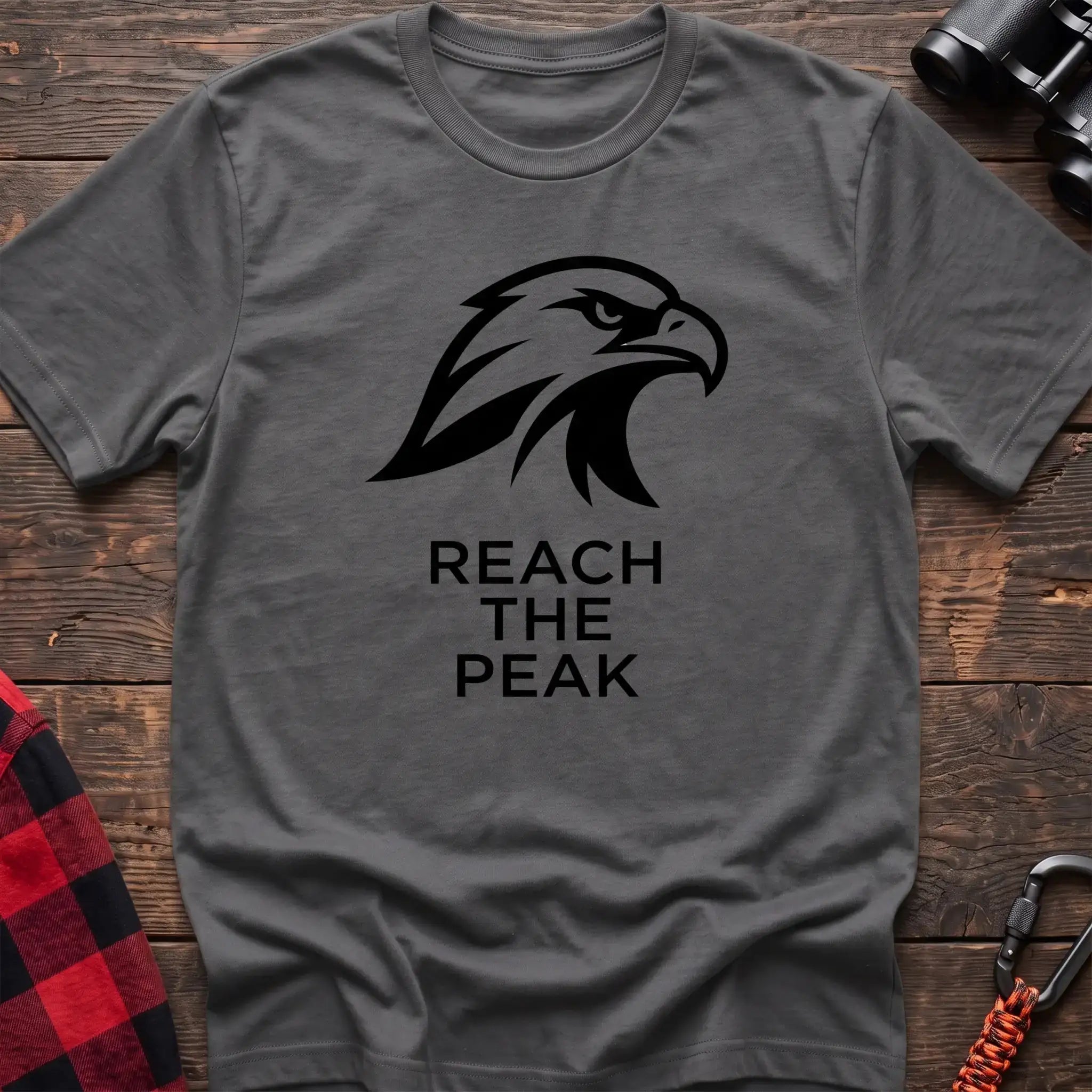 Graphite heather crew-neck t-shirt with a black stylized eagle head logo and the text “REACH THE PEAK” printed on the front
