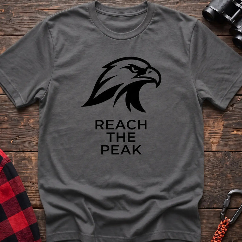 Graphite heather crew-neck t-shirt with a black stylized eagle head logo and the text “REACH THE PEAK” printed on the front