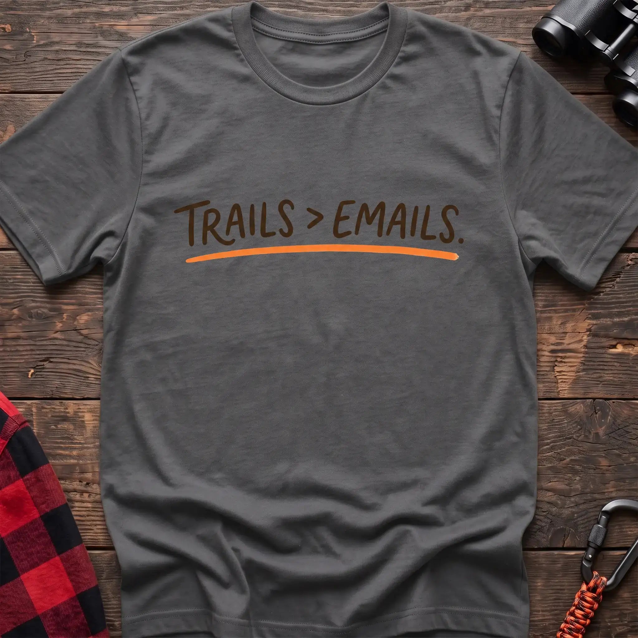 Graphite heather t-shirt with brown handwritten-style text reading Trails greater than Emails and an orange underline