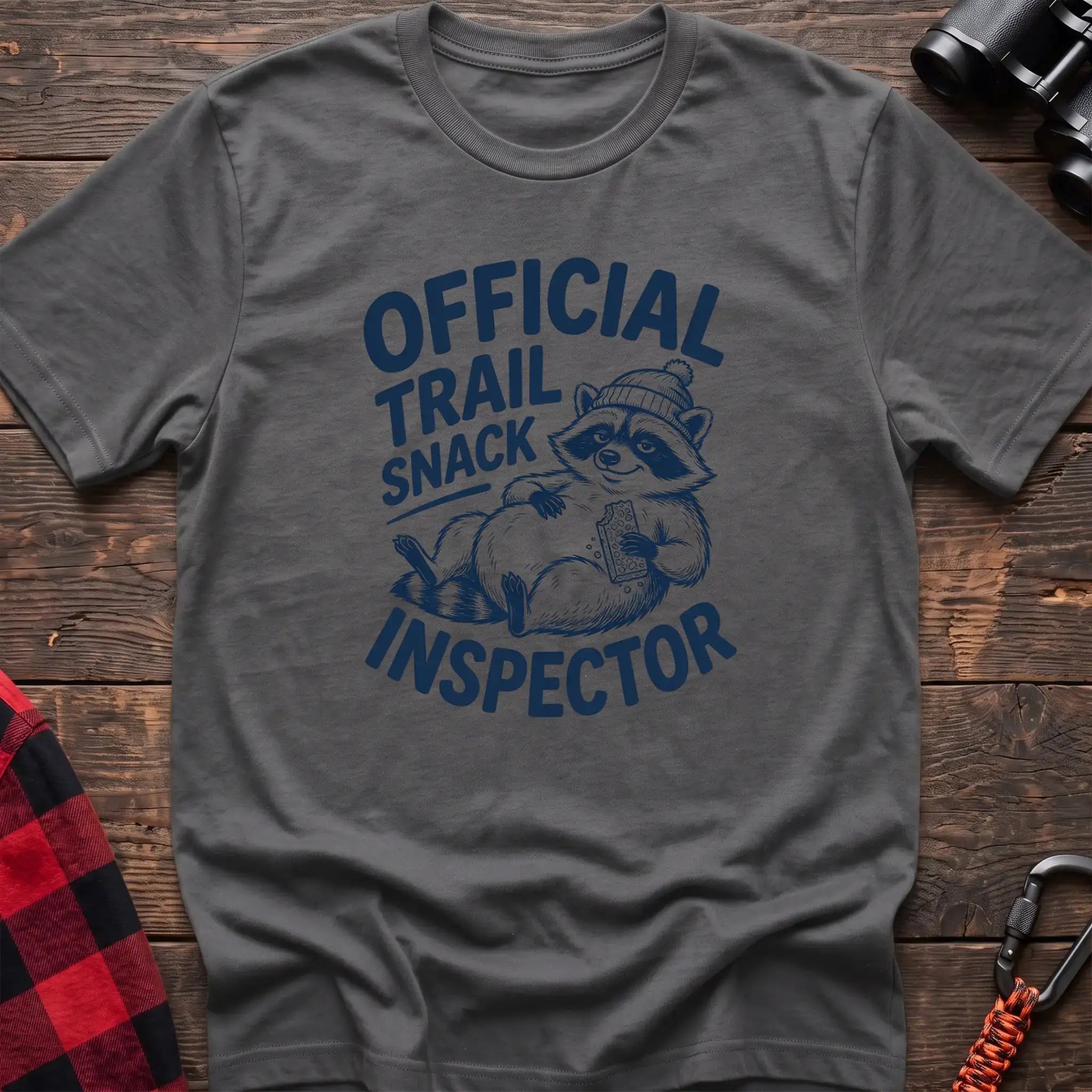 Graphite heather t-shirt with cartoon raccoon holding a snack and the text Official Trail Snack Inspector
