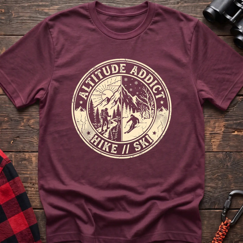 Heather maroon t-shirt with circular badge graphic of a hiker and skier on split mountain scenes, reading Altitude Addict Hike Ski