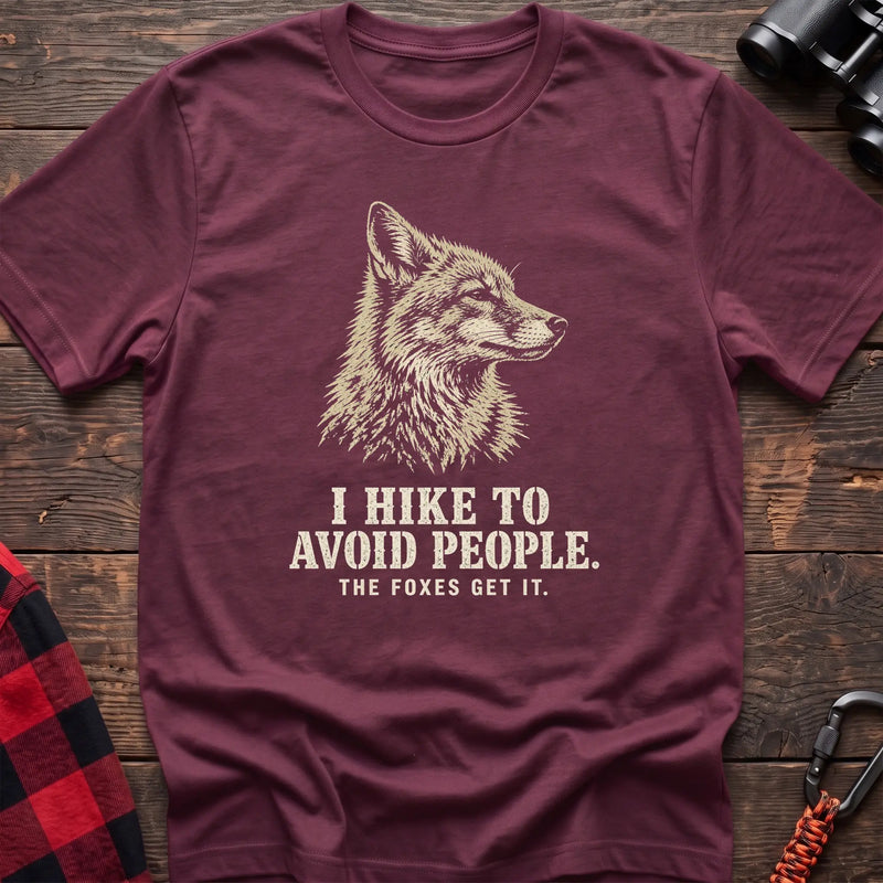 Heather maroon cotton t-shirt with a fox graphic and I Hike to Avoid People The Foxes Get It text on rustic wood