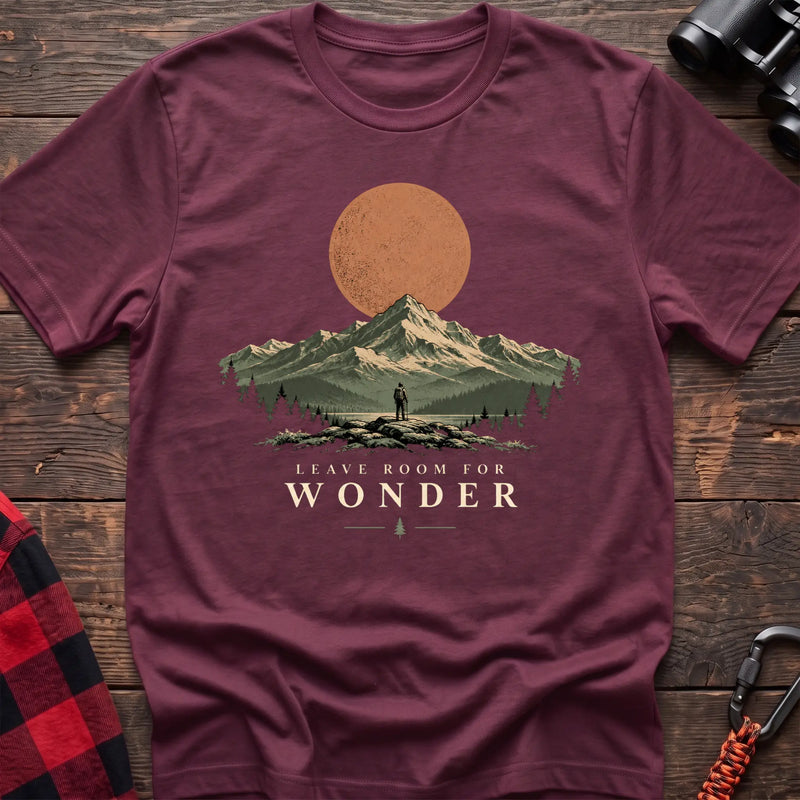 Heather maroon cotton t-shirt with a hiker and mountain sunset graphic and Leave Room for Wonder text on rustic wood