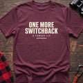 Heather maroon cotton t-shirt with One More Switchback A Famous Lie text on rustic wood
