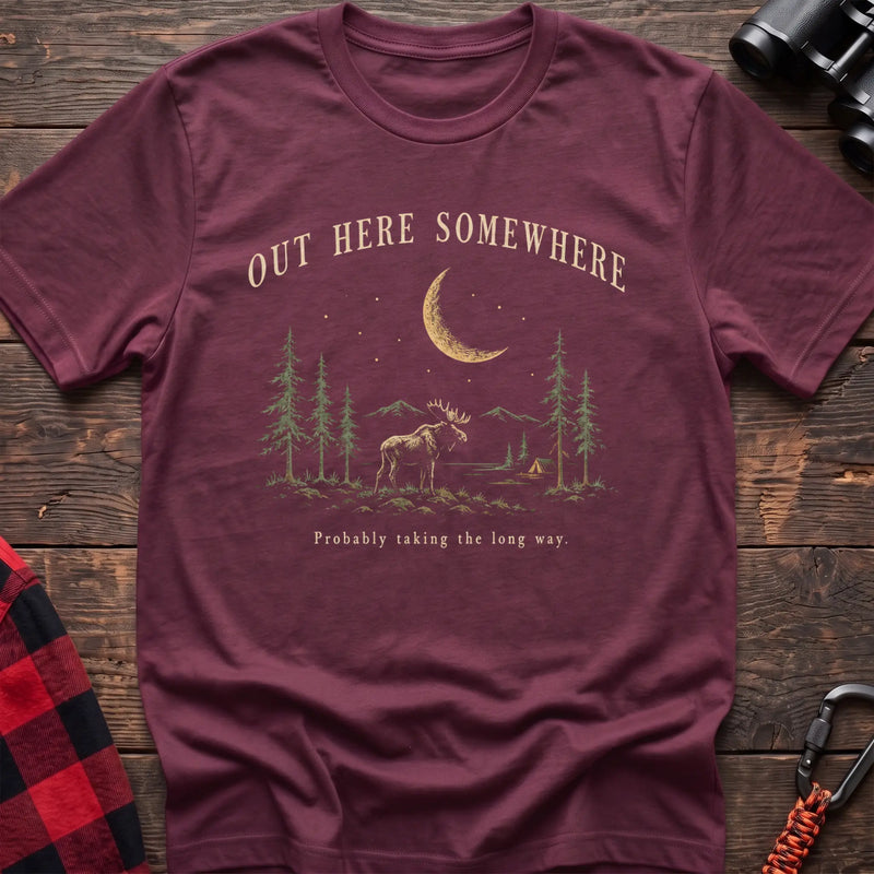Heather maroon cotton t-shirt with a moonlit moose and pines graphic and Out Here Somewhere text on rustic wood