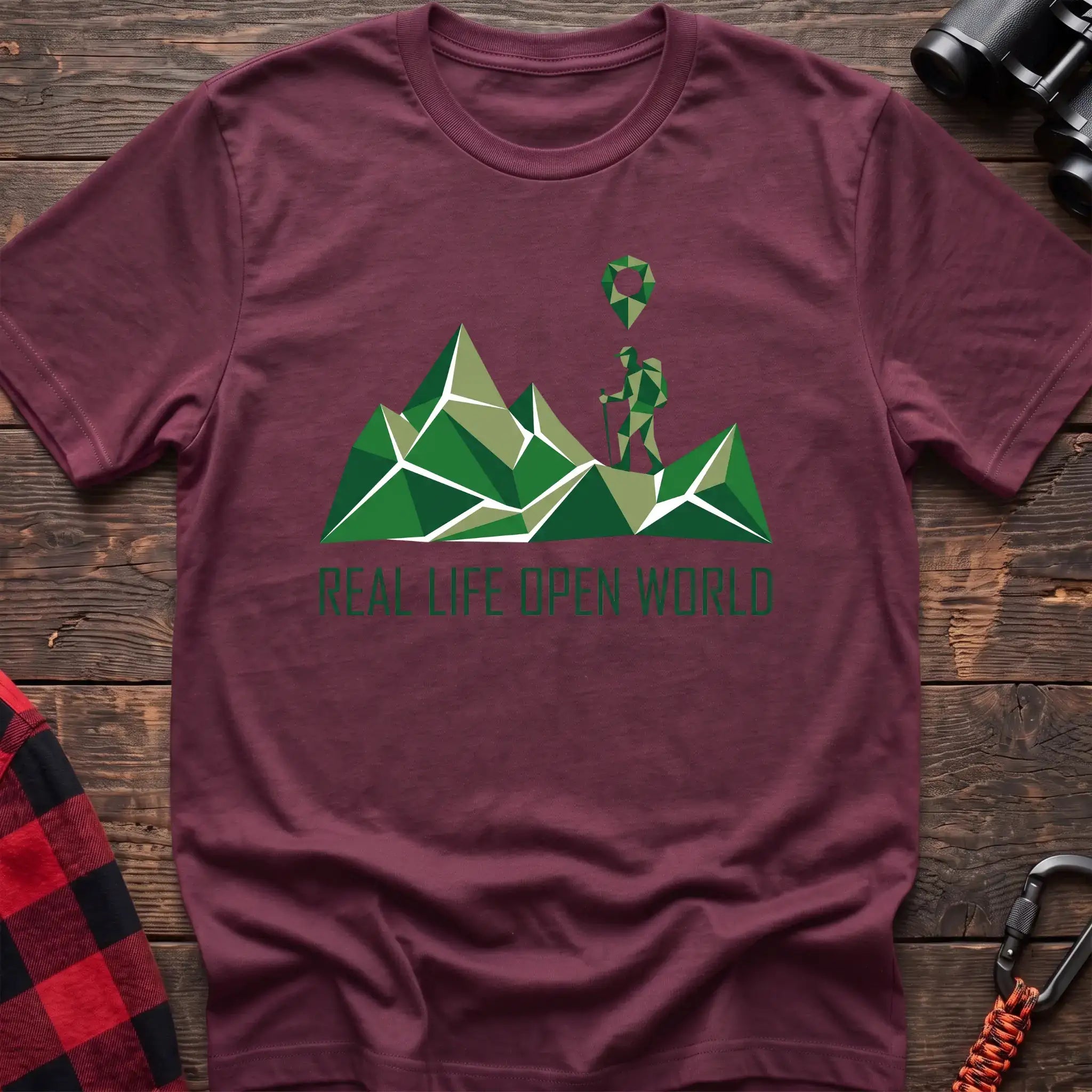 Heather maroon t-shirt with geometric green mountain graphic and a hiker silhouette under a map pin, reading Real Life Open World