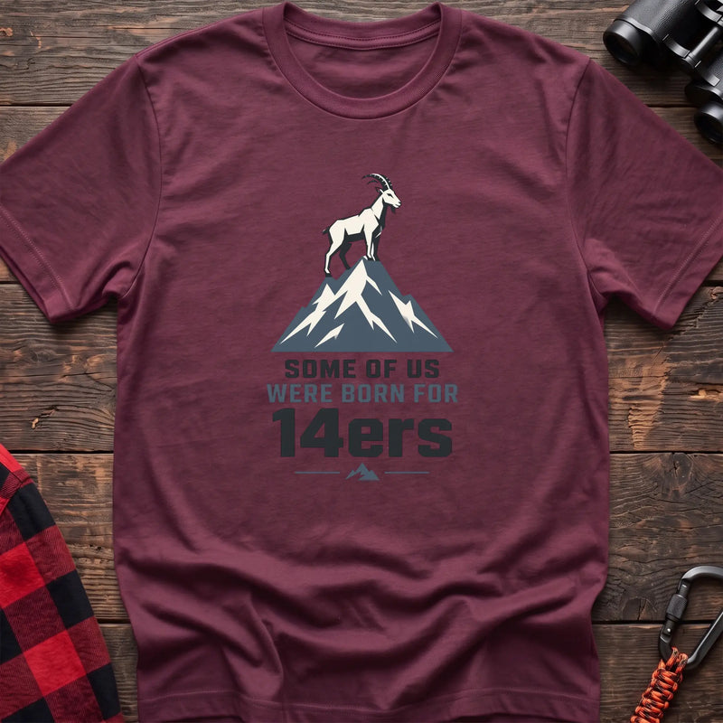 Heather maroon hiking t-shirt with a mountain goat on a peak and the text “Some of Us Were Born for 14ers”