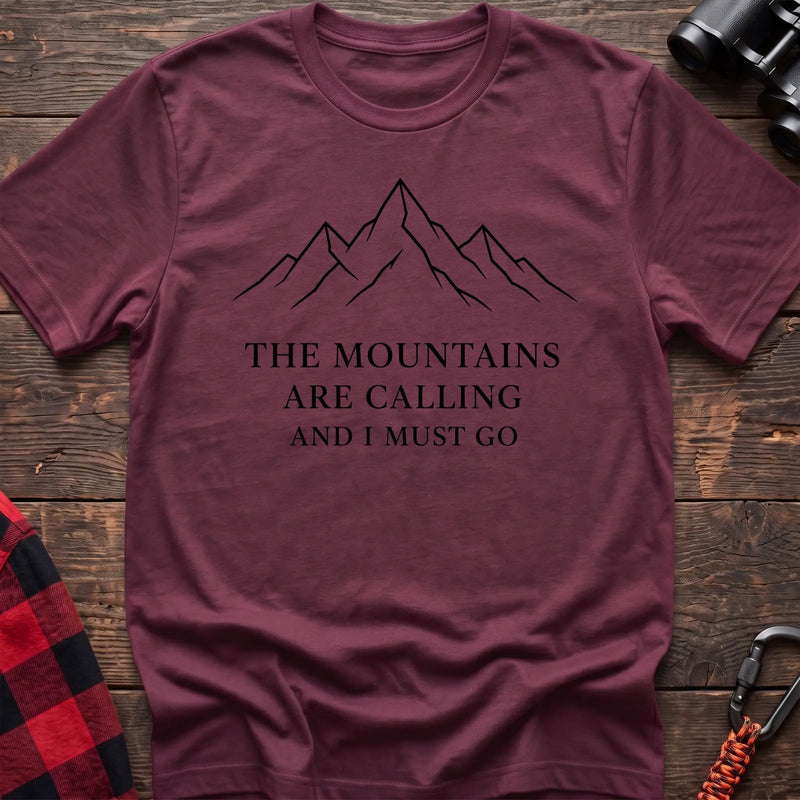 Heather maroon cotton hiking t-shirt with simple mountain line drawing and "The mountains are calling and I must go" quote