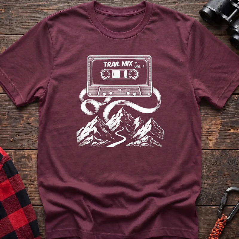 Heather maroon t-shirt with white cassette tape graphic labeled Trail Mix Vol. 1, with tape unspooling into a trail through mountains