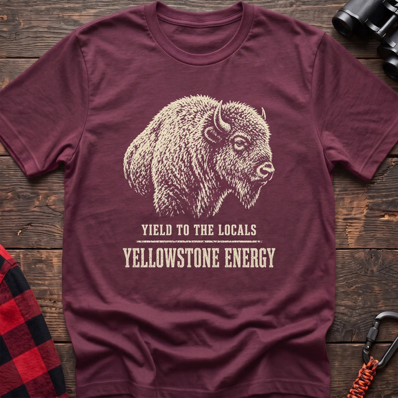Heather maroon cotton t-shirt with a bison graphic and Yield to the Locals Yellowstone Energy text on rustic wood