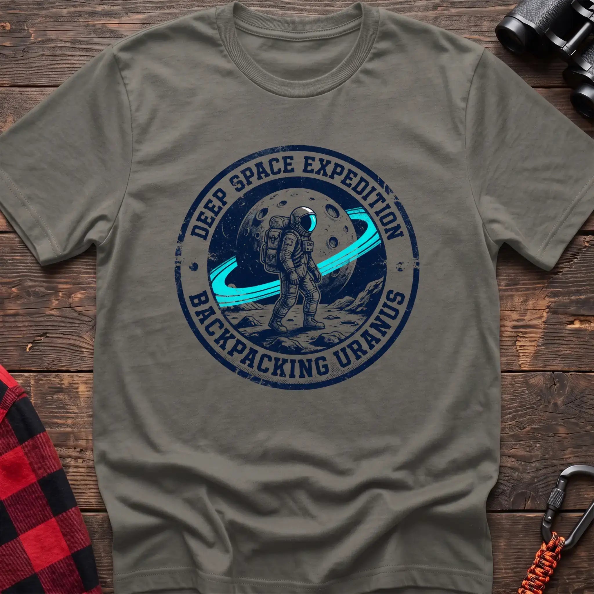 Heather military green  t-shirt with circular badge graphic of an astronaut backpacking on Uranus, reading Deep Space Expedition Backpacking Uranus