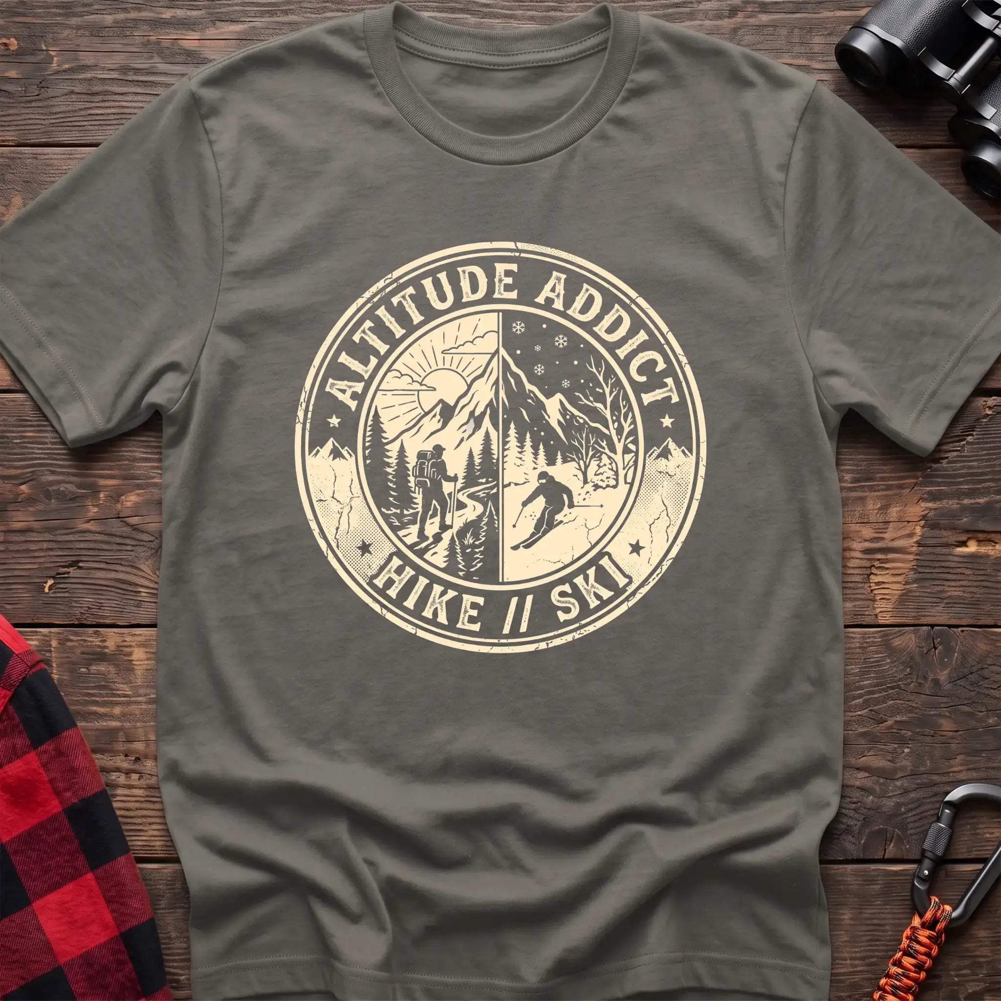 Heather military green t-shirt with circular badge graphic of a hiker and skier on split mountain scenes, reading Altitude Addict Hike Ski