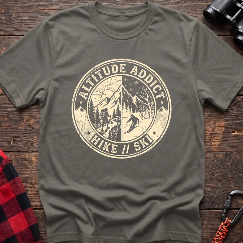 Heather military green t-shirt with circular badge graphic of a hiker and skier on split mountain scenes, reading Altitude Addict Hike Ski