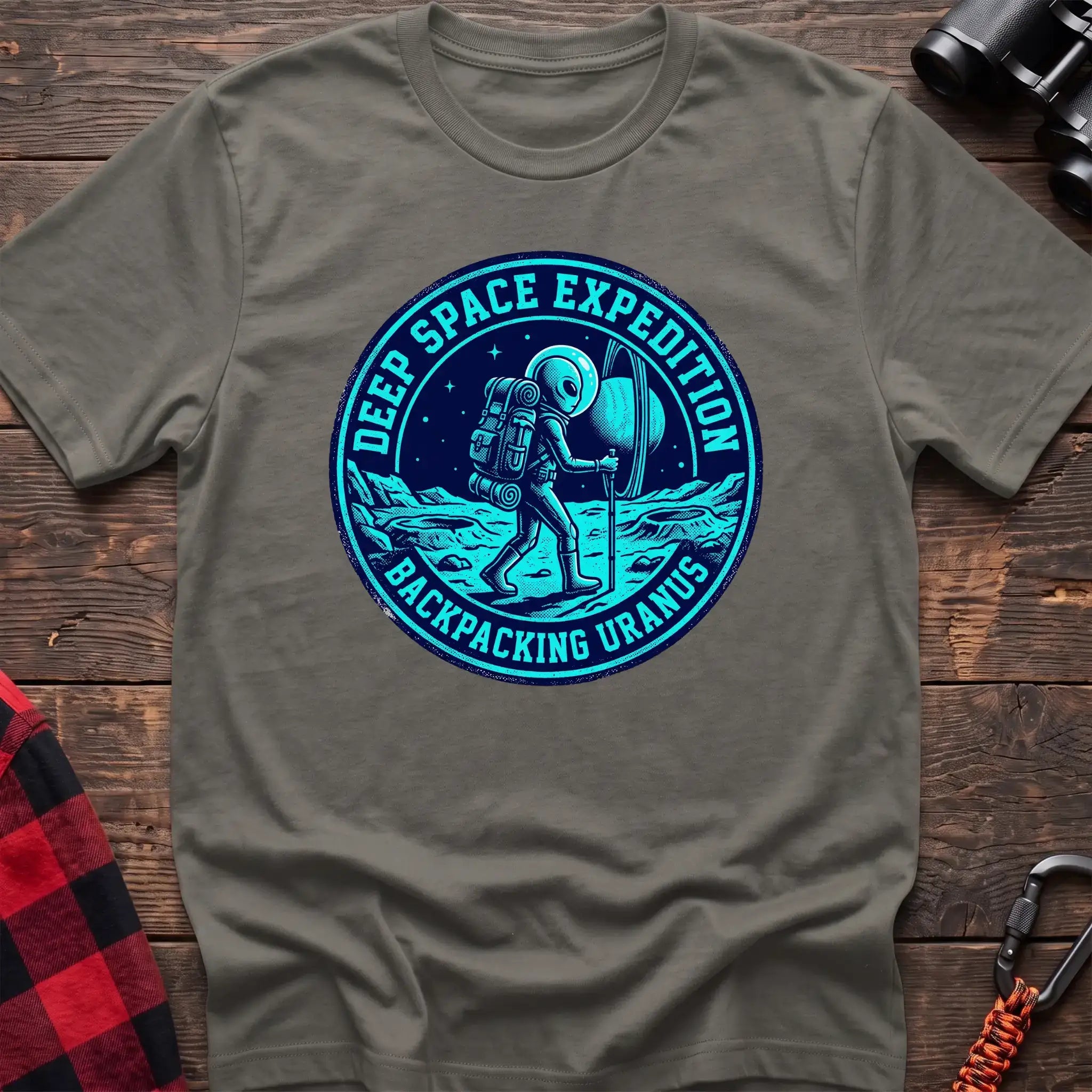 Heather military green t-shirt with circular badge graphic of an alien backpacking on Uranus, reading Deep Space Expedition Backpacking Uranus