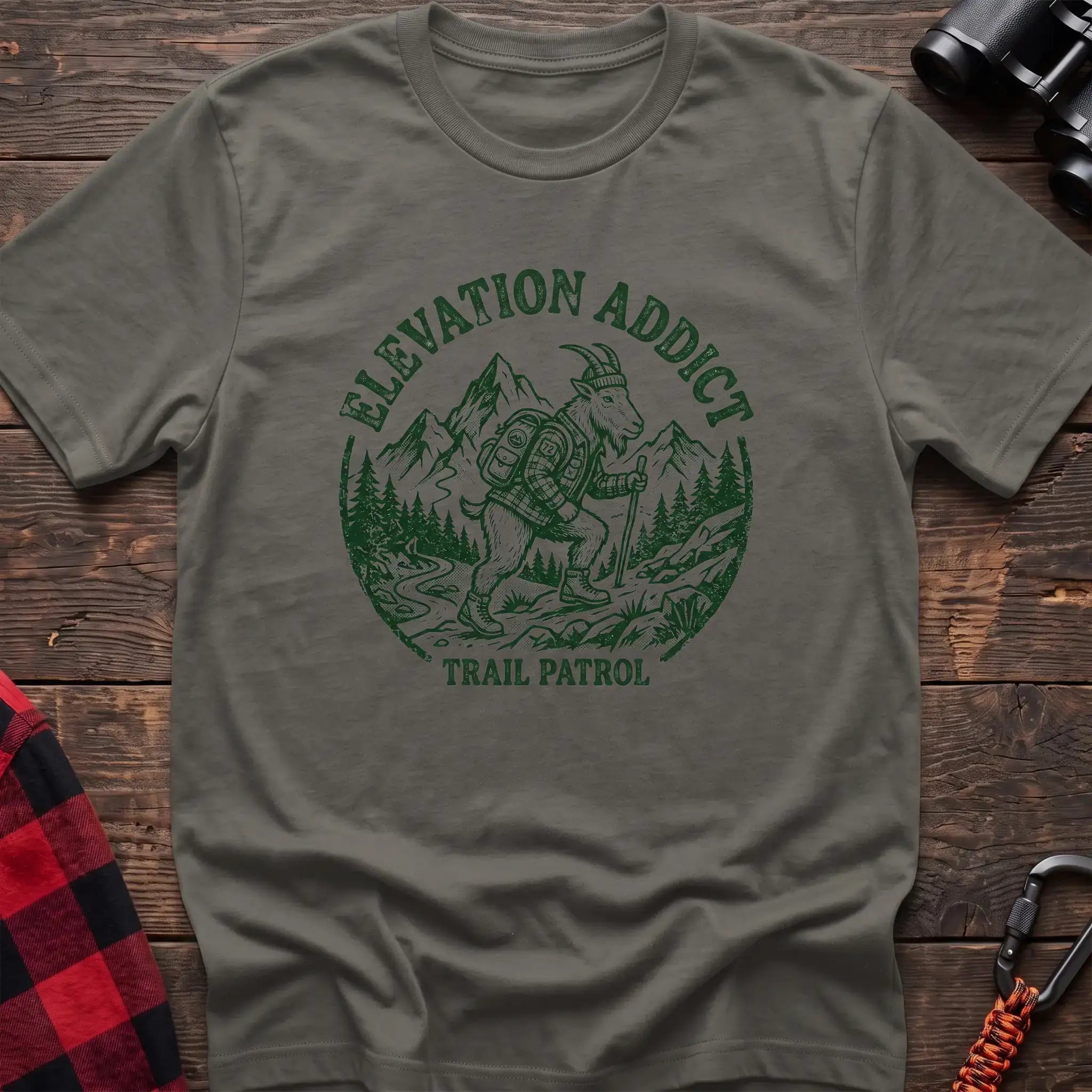 Heather military green t-shirt with circular graphic of a hiking mountain goat and the text Elevation Addict Trail Patrol