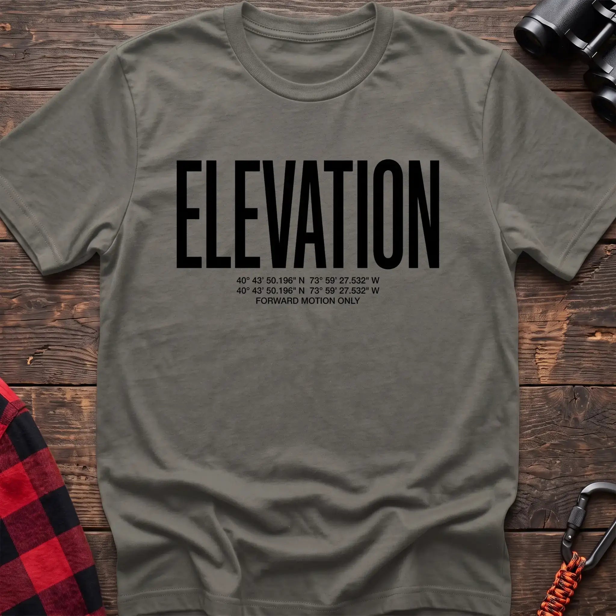 Heather military green t-shirt with large black text reading Elevation and GPS coordinates with Forward Motion Only