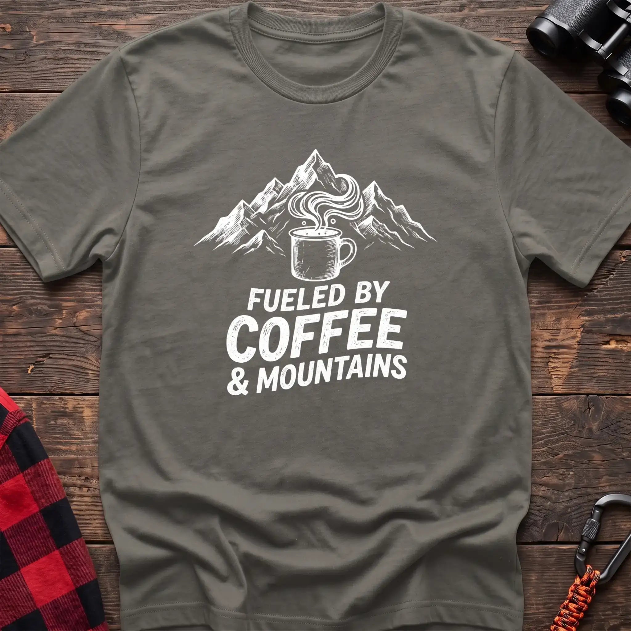 Heather military green t-shirt with white graphic of a steaming coffee mug in front of mountains and the text Fueled by Coffee & Mountains